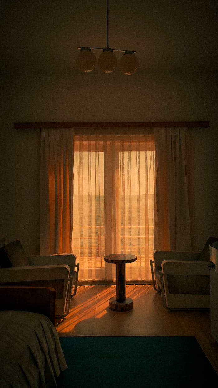 A serene minimalist bedroom with warm sunlight streaming through sheer curtains, enhancing its cozy ambiance.